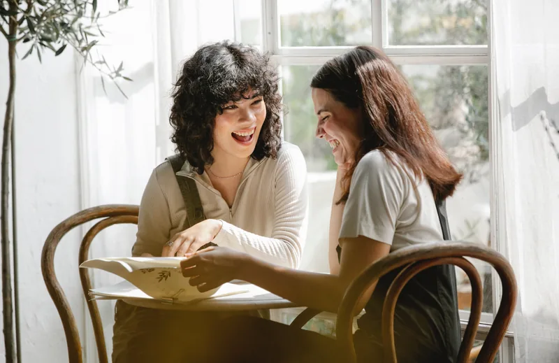 Beyond the Book: two colleagues talking in warm natural light.