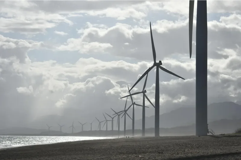 The Old School Yard Co: wind turbines along a coastline, the offshore world it supplies into.