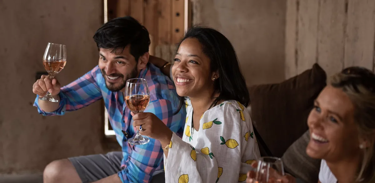 Xped Global travellers raising glasses of rosé at a rustic stop on the journey.